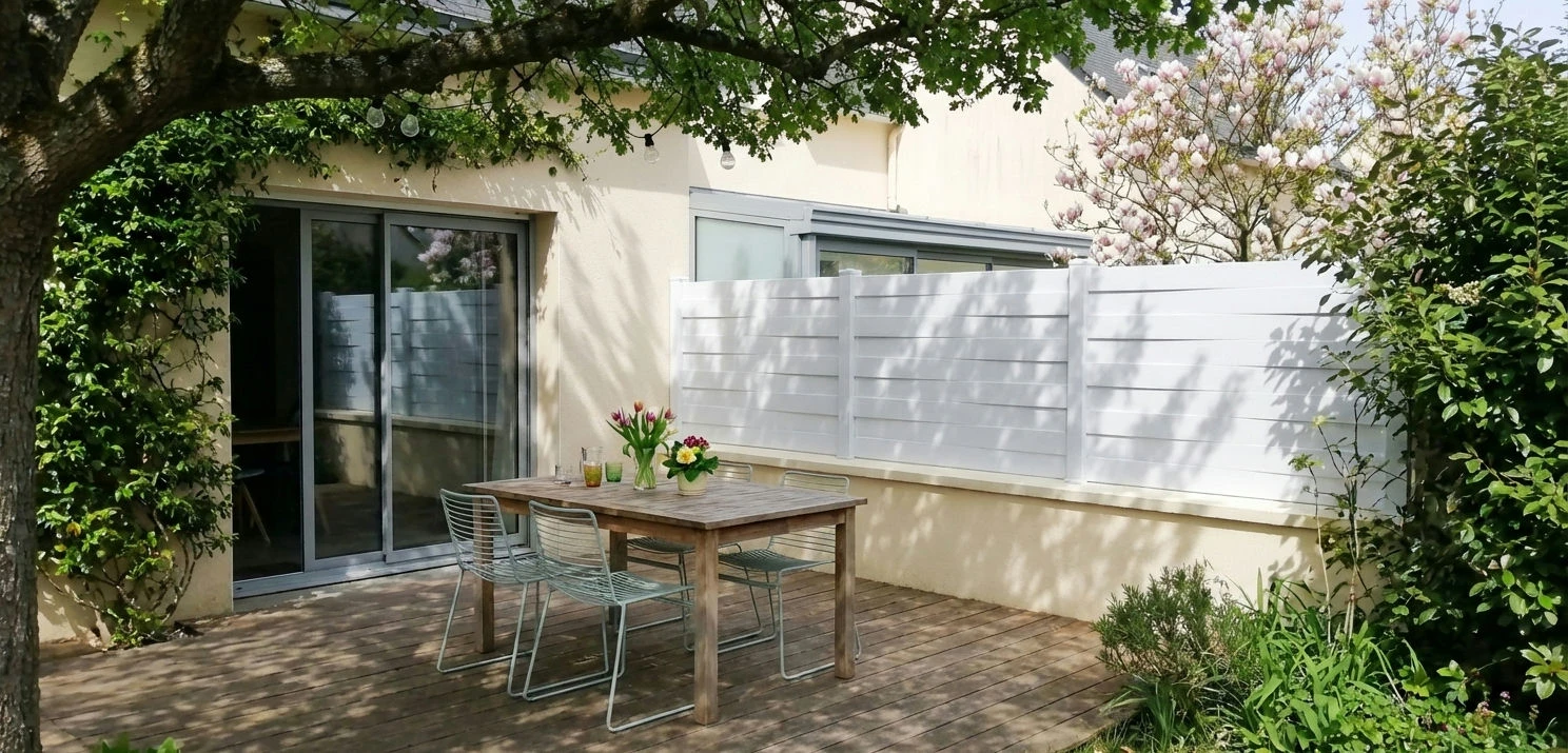 clôture blanche mitoyenne dans un jardin paisible